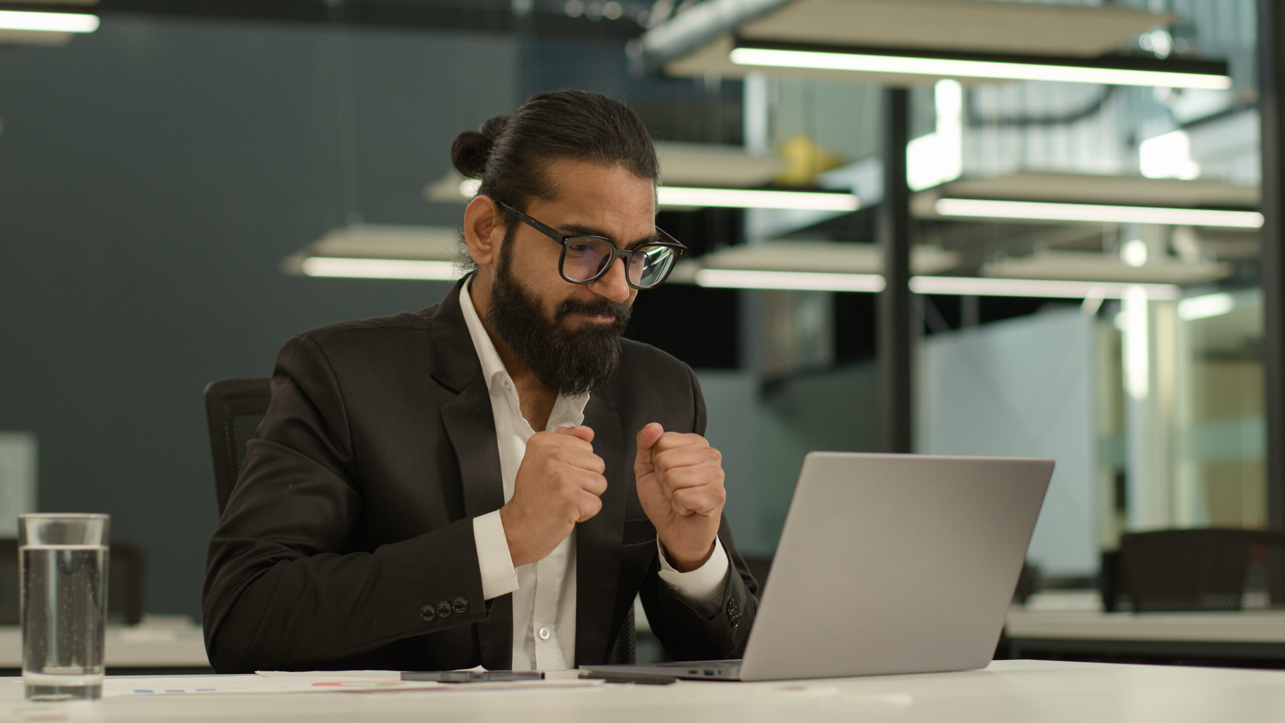Pensive thinking business man Indian gut Arabian businessman boss hope wish pray male Muslim entrepreneur working with laptop think thoughtful rubbing hands ponder idea computer task wish in office