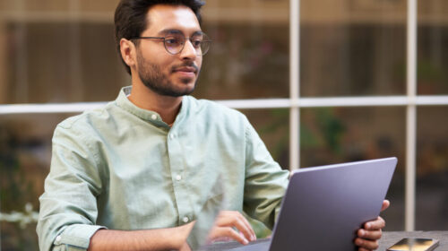 Stylish businessman sitting in modern coworking and working on laptop. High quality photo Stylish businessman sitting in modern coworking and working on laptop. High quality photo
