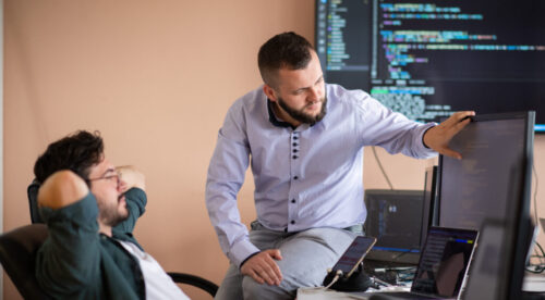 Programmers engrossed in deep collaboration, diligently working together to solve complex problems Programmers engrossed in deep collaboration, diligently working together to solve complex problems